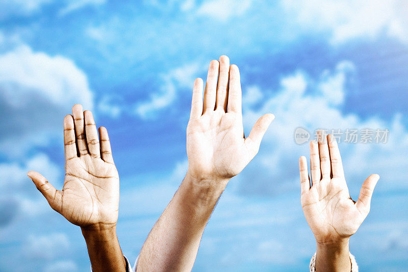 Hands waving or making the Stop gesture, held aloft against a summer sky with a dusting of cloud